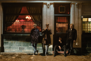 The Milk band cool photograph outside pub east London wearing dark colours, smoking in the twilight. Rock n roll